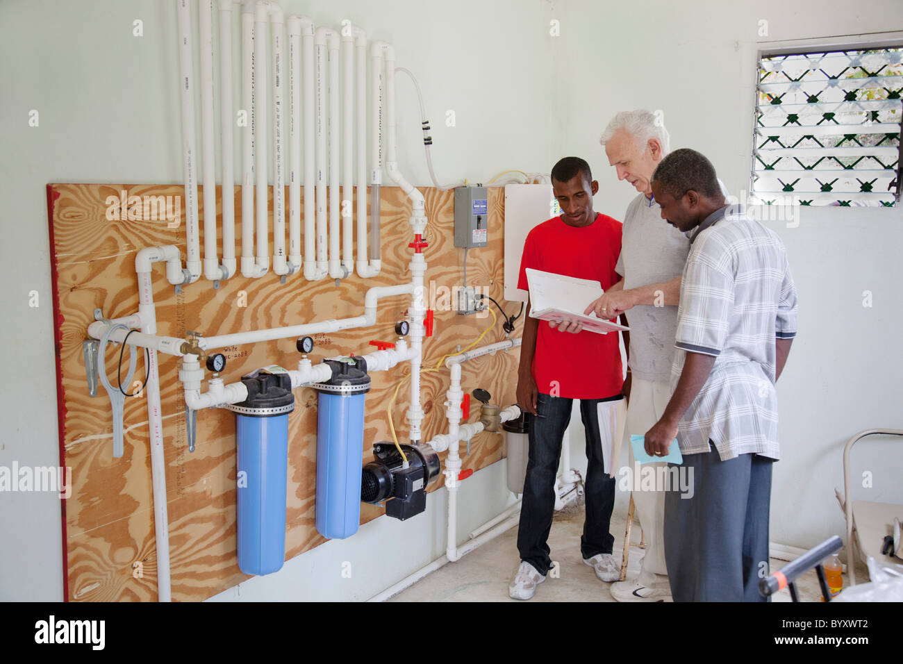 an american man trains young haitians on a clinic's water treatment system; grand saline, haiti Stock Photo