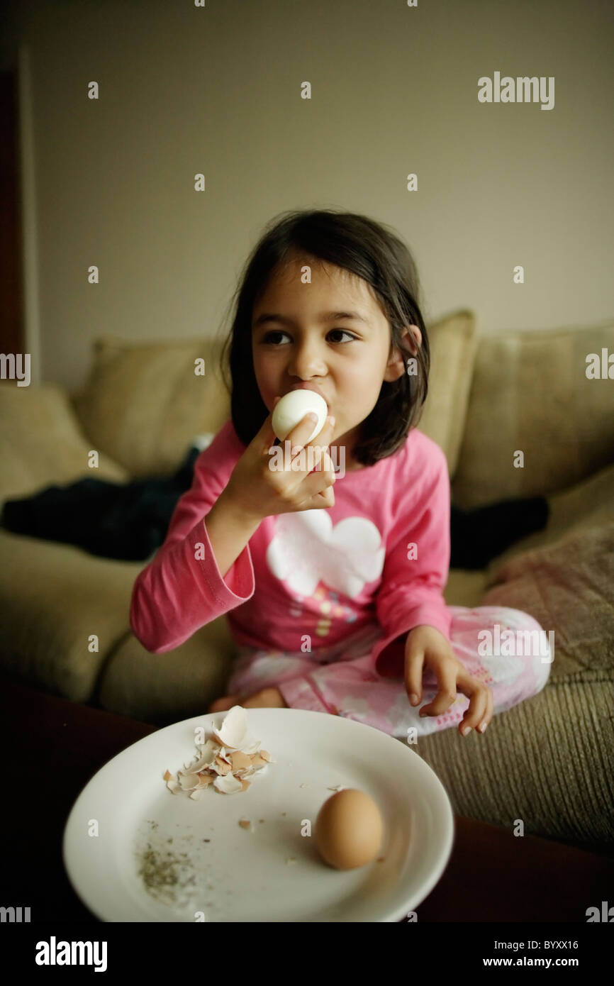 Girl eats hard boiled eggs. Stock Photo