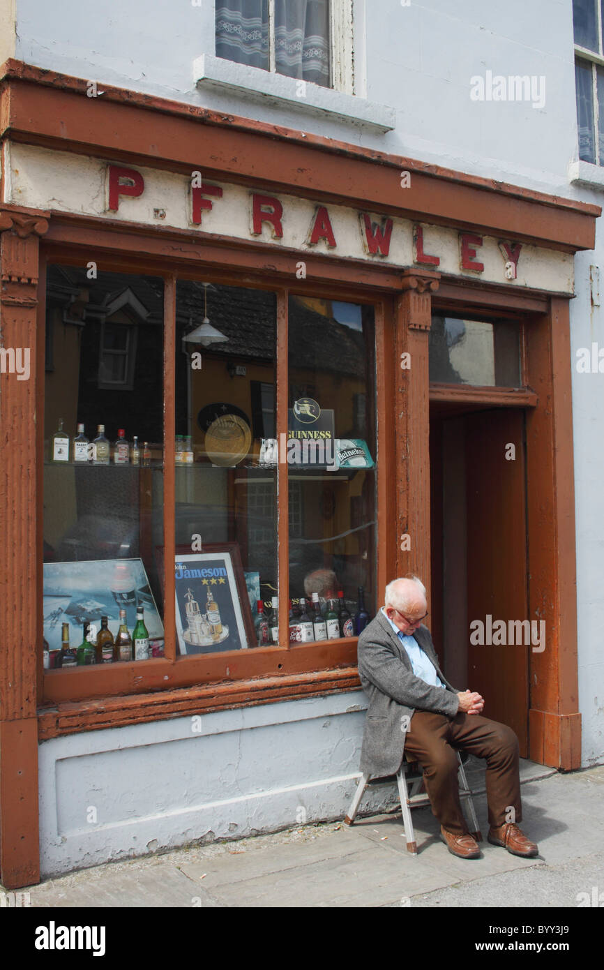 man asleep on a chair outside a pub in munster region; lahinch, county clare, ireland Stock Photo