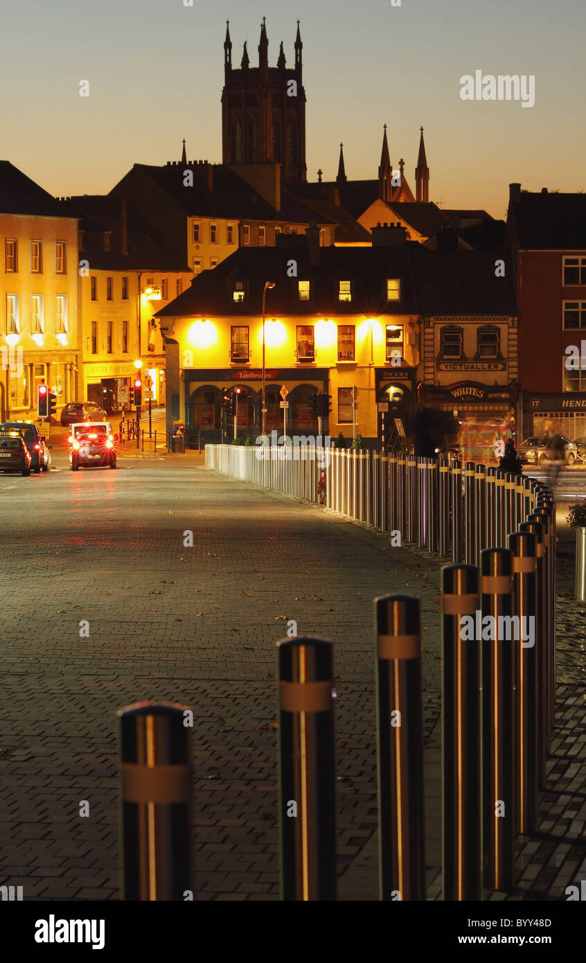 a road leading to illuminated buildings at night in leinster region; kilkenny, county kilkenny, ireland Stock Photo