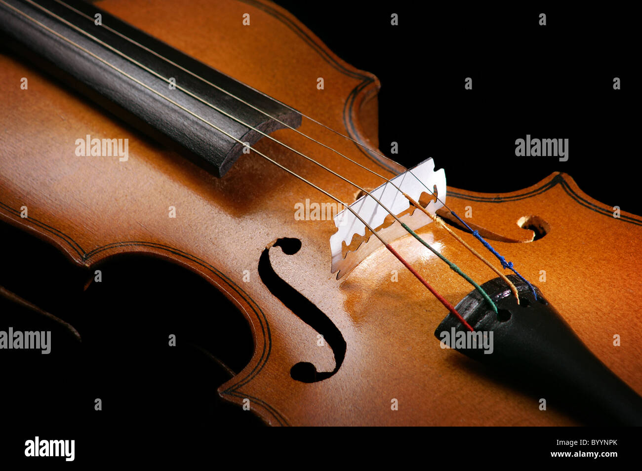 Violin close up with a razor blade at the place of the bridge Stock