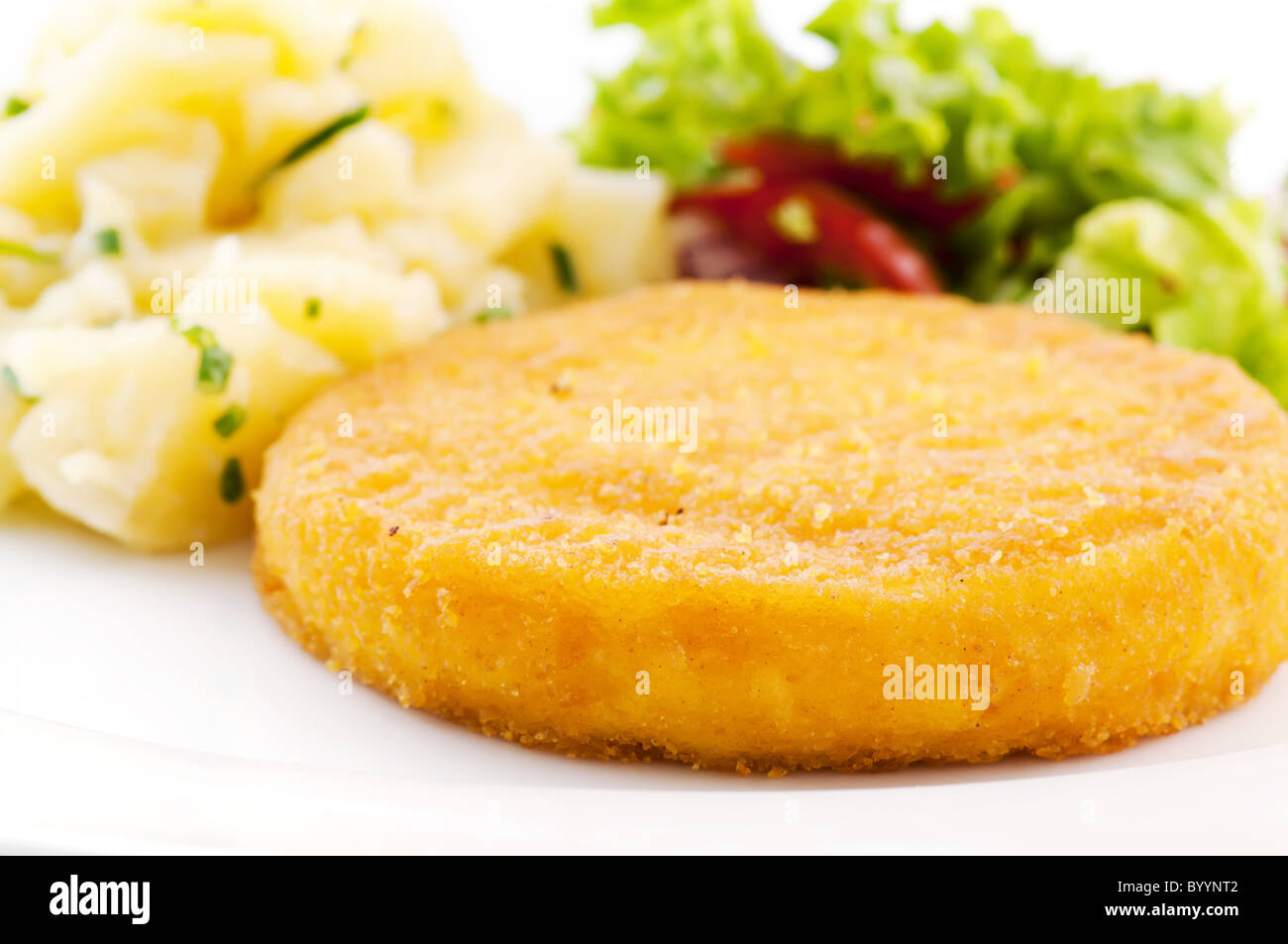 Breaded scalloped camembert with potatoes and salad Stock Photo