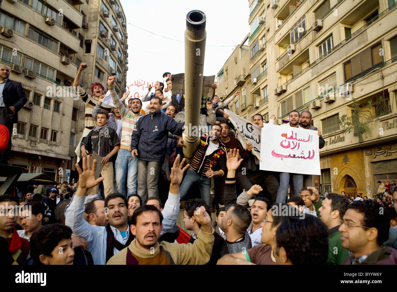 Anti-government protesters crowd atop an army tank during the demonstrations in Tahrir Square on Jan.29, 2011 in Cairo, Egypt. Stock Photo