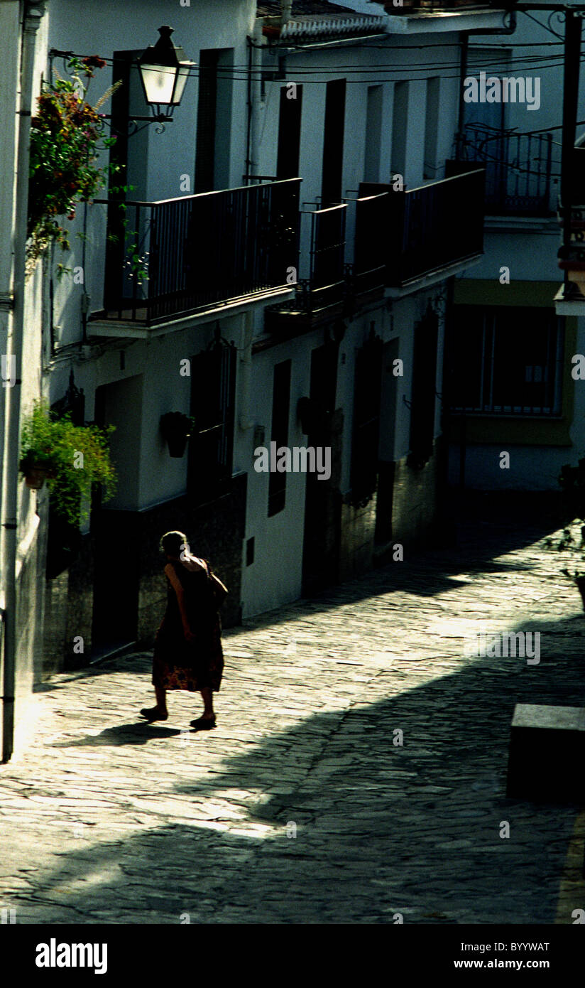 Elderly lady walks across street in Andalucian village of Alozaina Stock Photo