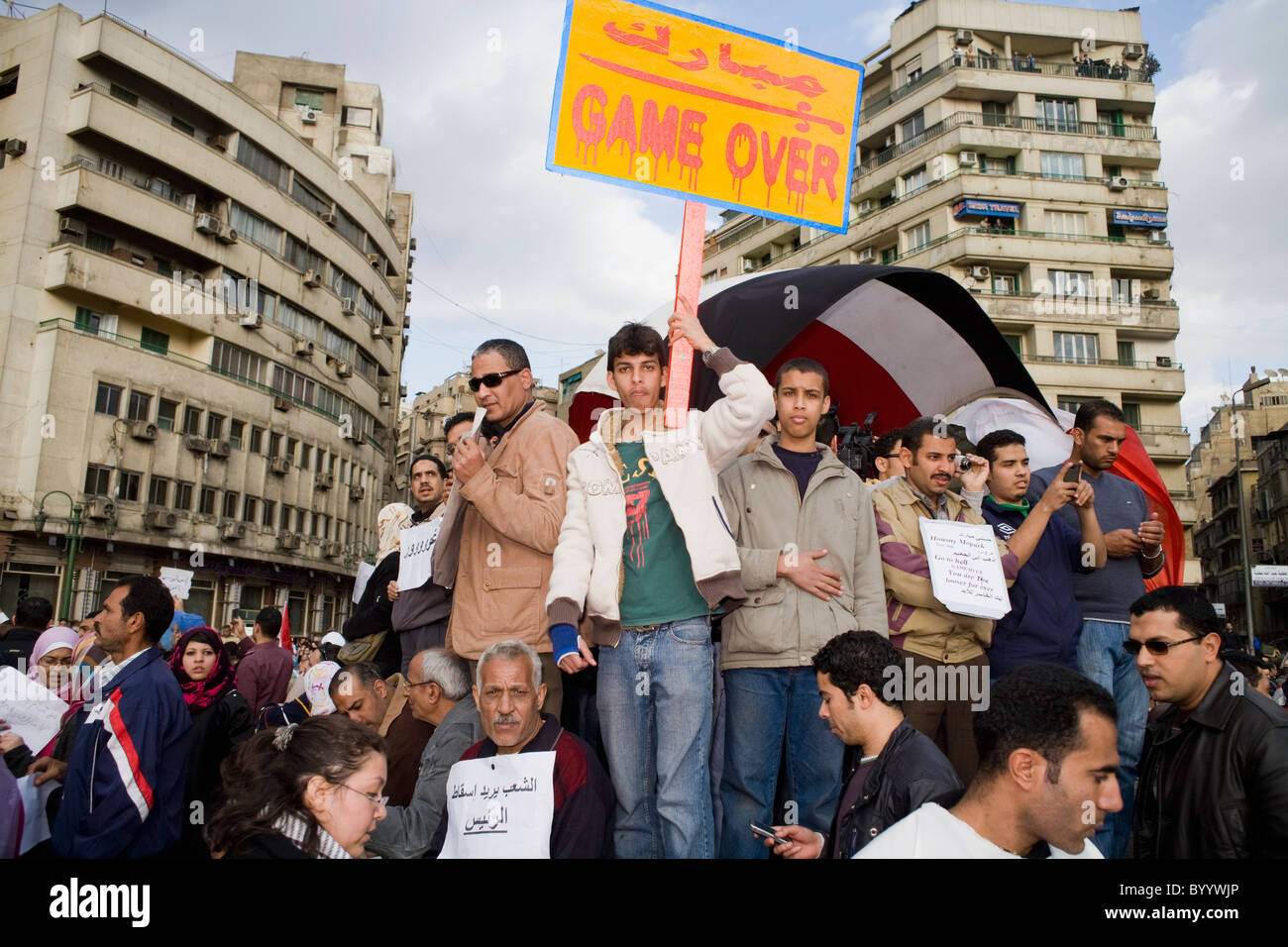 A young man holds a sign amidst a crowd of people in Tahrir Square that says, 'Game Over', Cairo, Egypt on Jan.31, 2011 Stock Photo