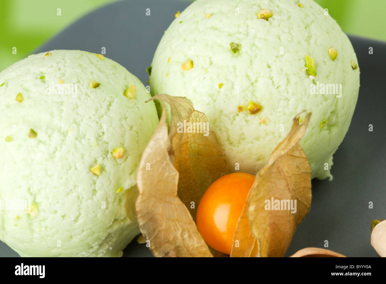 two scoops of pistachio ice cream and a winter cherry fruit Stock Photo