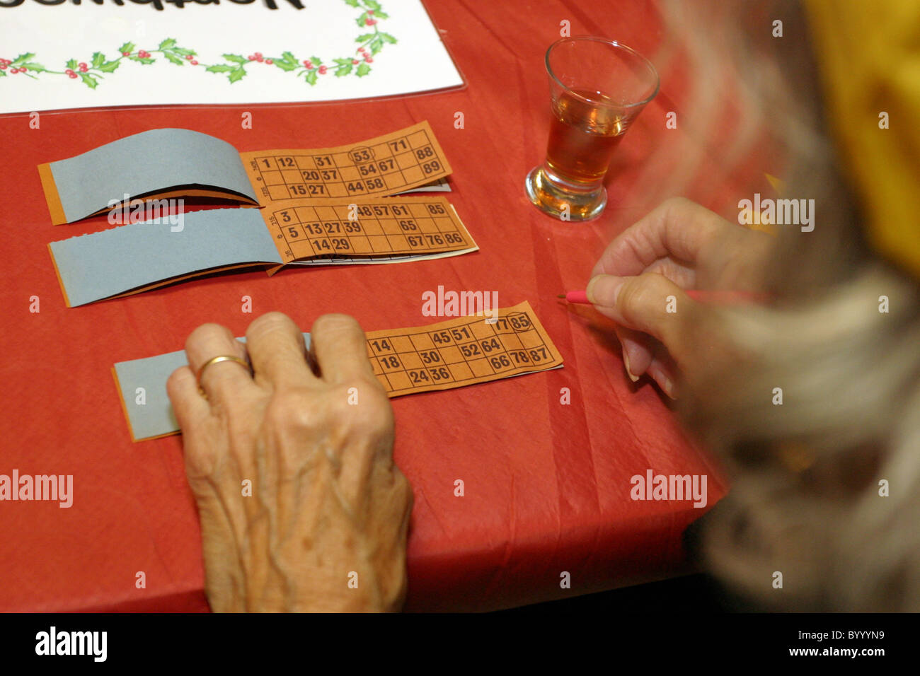 Older person filling in card for playing Bingo Stock Photo