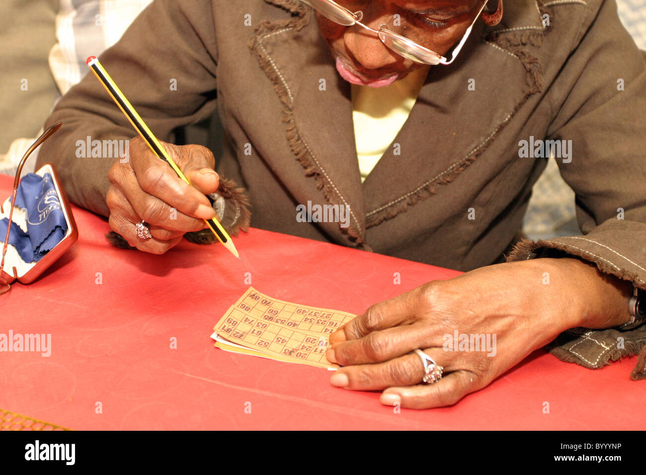 Older person filling in card for playing Bingo Stock Photo