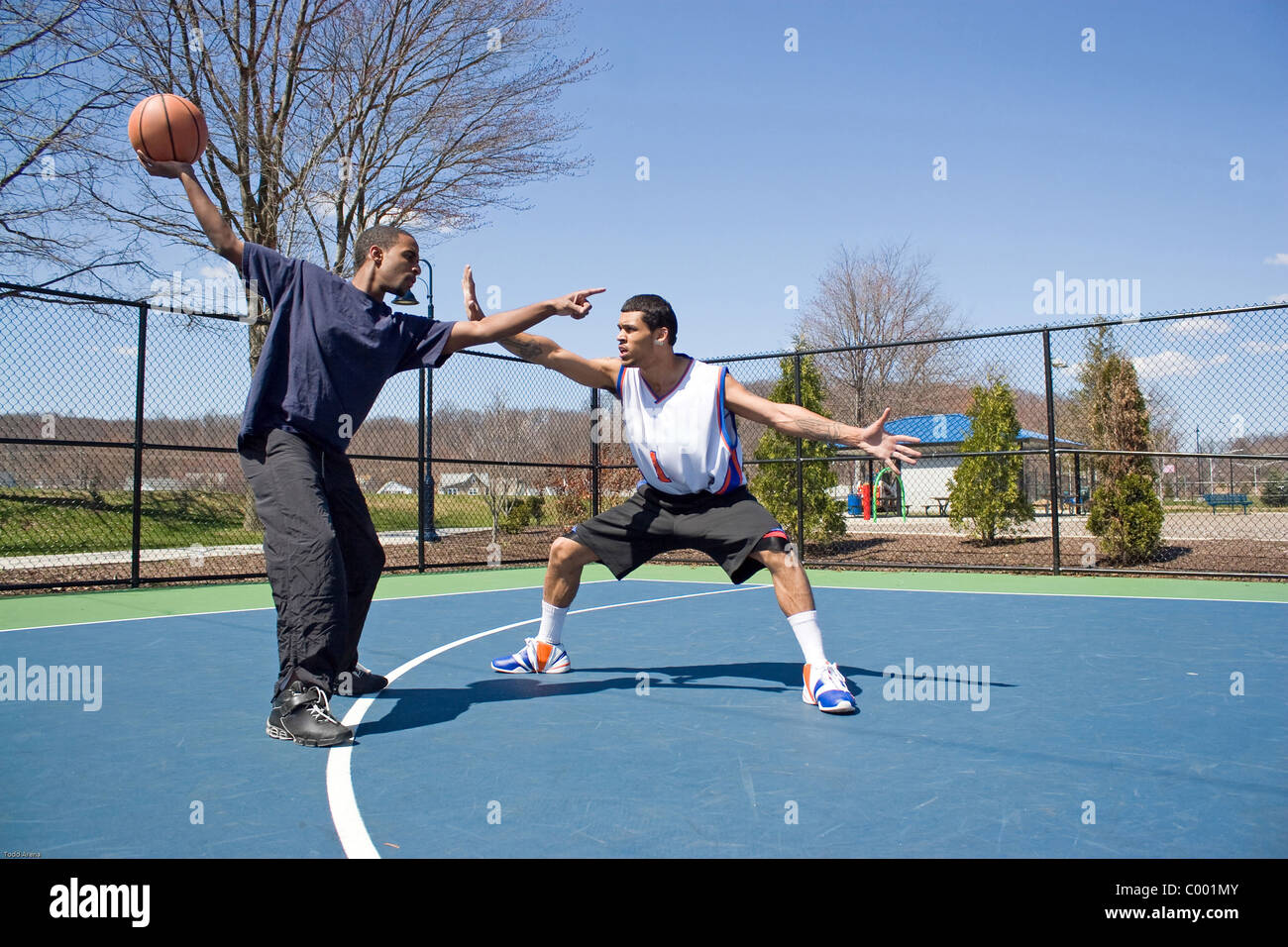 A young basketball player guarding his opponent during a one on one basketball game. Stock Photo