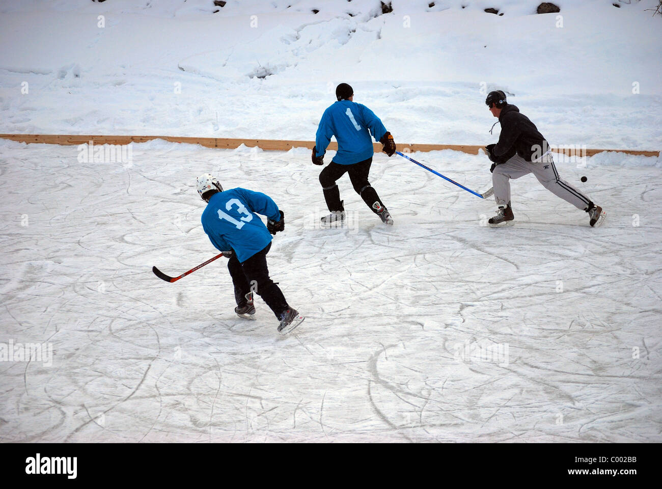 Amateur adult hockey players race for puck. Stock Photo