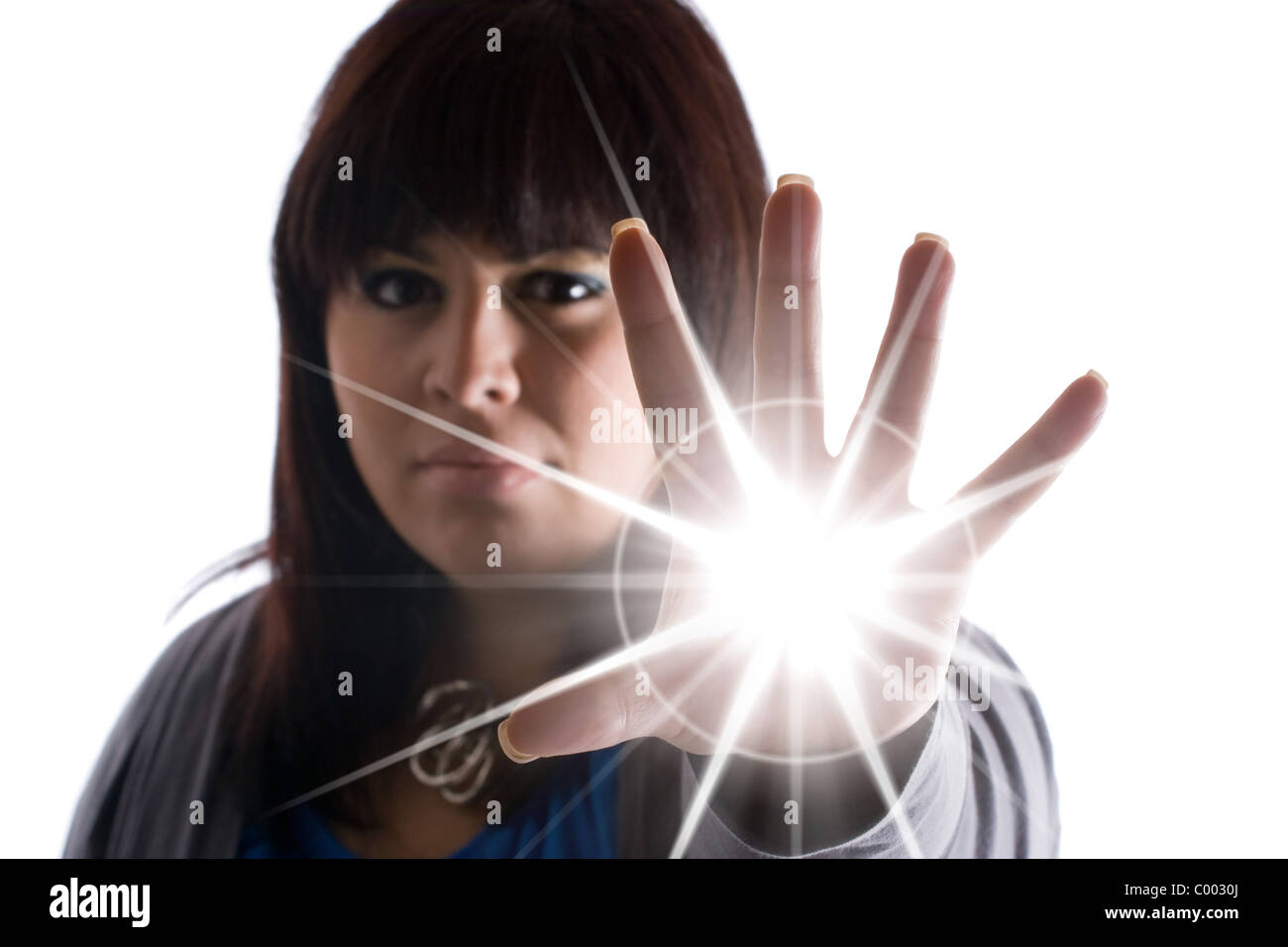 A woman with special powers shooting a burst of light or energy of some sort from the palm of her hand. Stock Photo
