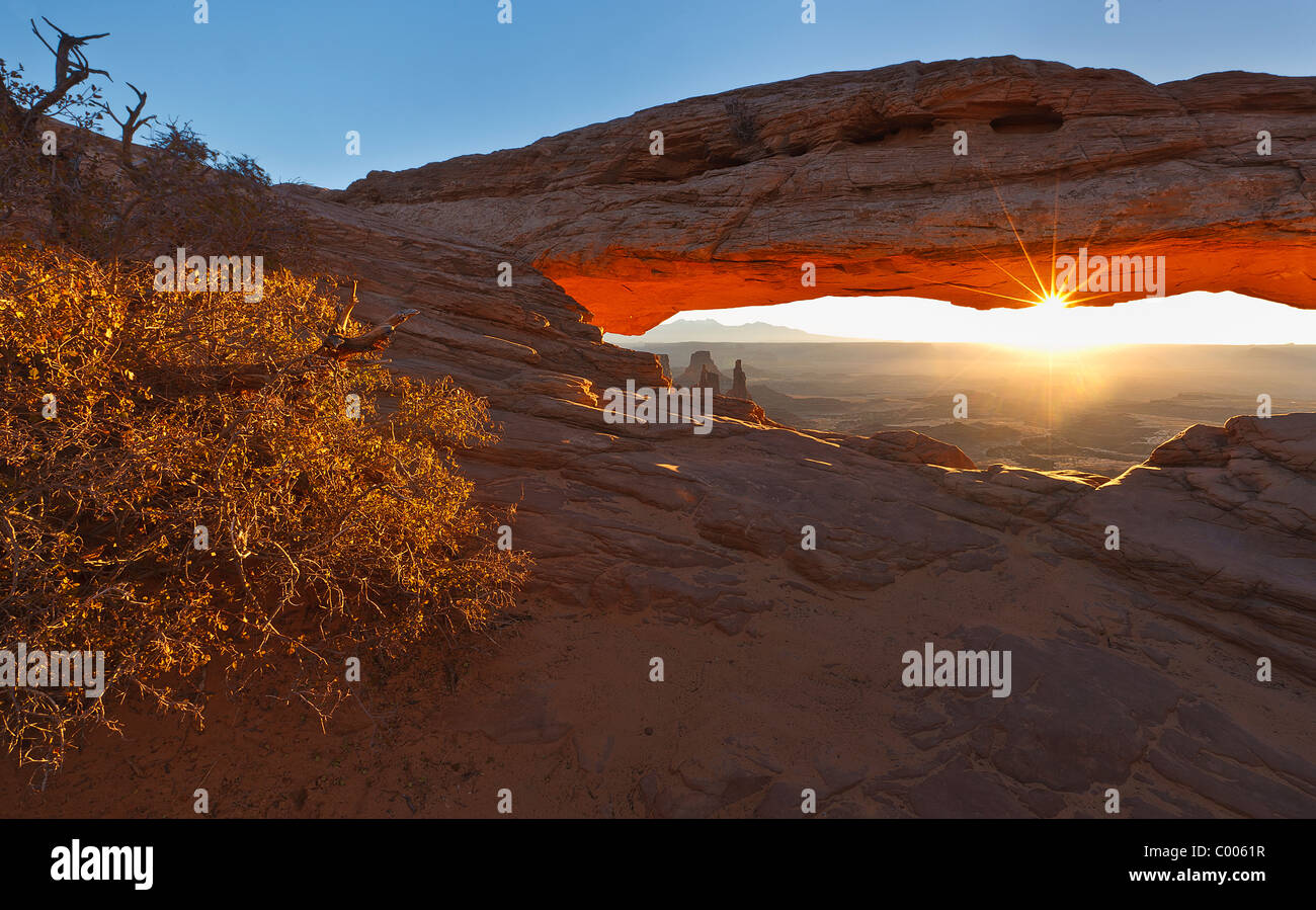 A sunrise sunstar lights the landscape at Mesa Arch in Canyonlands National Park, Utah, USA. Stock Photo