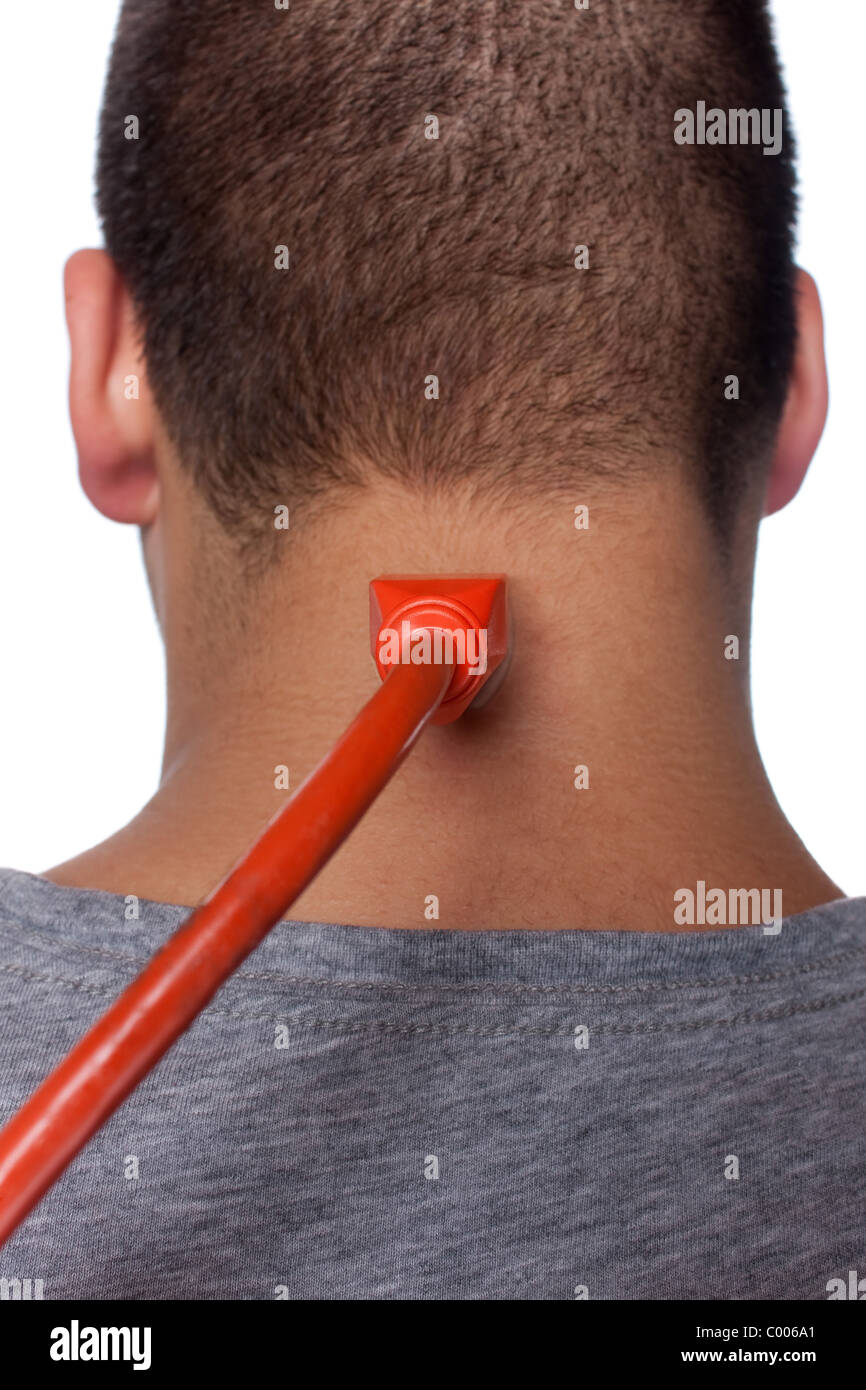 Conceptual image of a young man with an electrical cord plugged into electrical socket on the back of his neck. Stock Photo