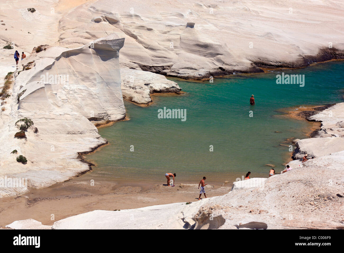 People swimming in Sarakiniko beach, famous for its blinding white volcanic rocks. Milos island, Cyclades, Greece Stock Photo