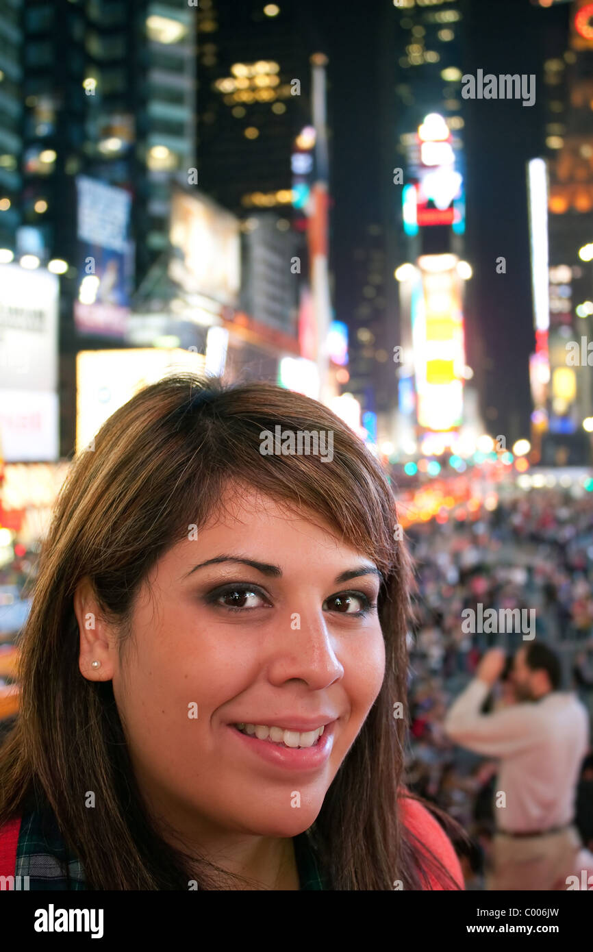 A young woman smiling as she stands in Times Square in New York City. Stock Photo
