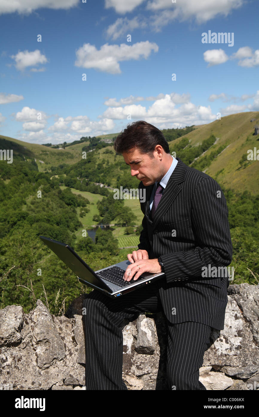 Business man working outside with mobile broadband and laptop Stock Photo -  Alamy