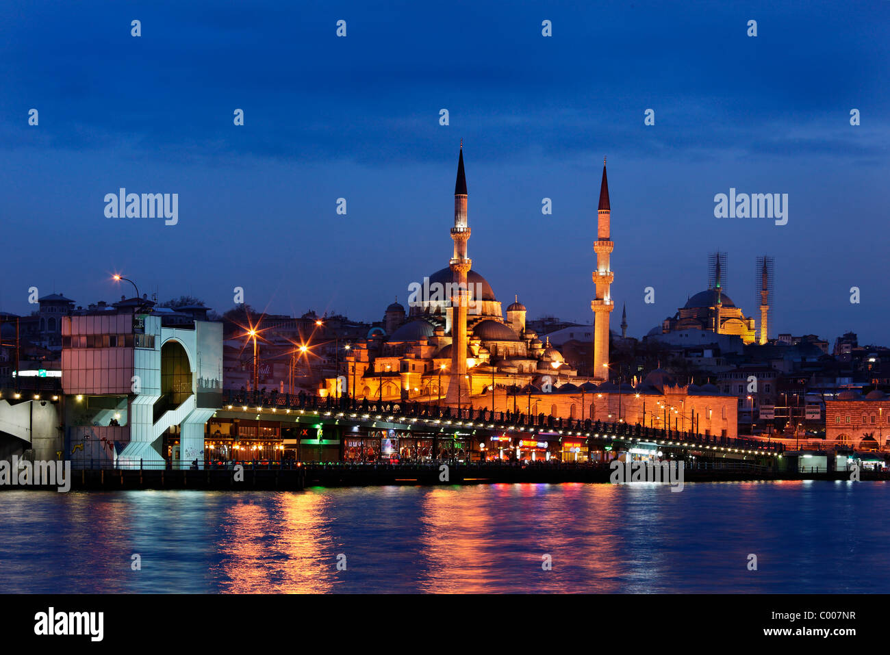 Night view of Yeni Camii ('New Mosque') and half of the Galata bridge, at the 'exit' of the Golden Horn. Istanbul, Turkey Stock Photo