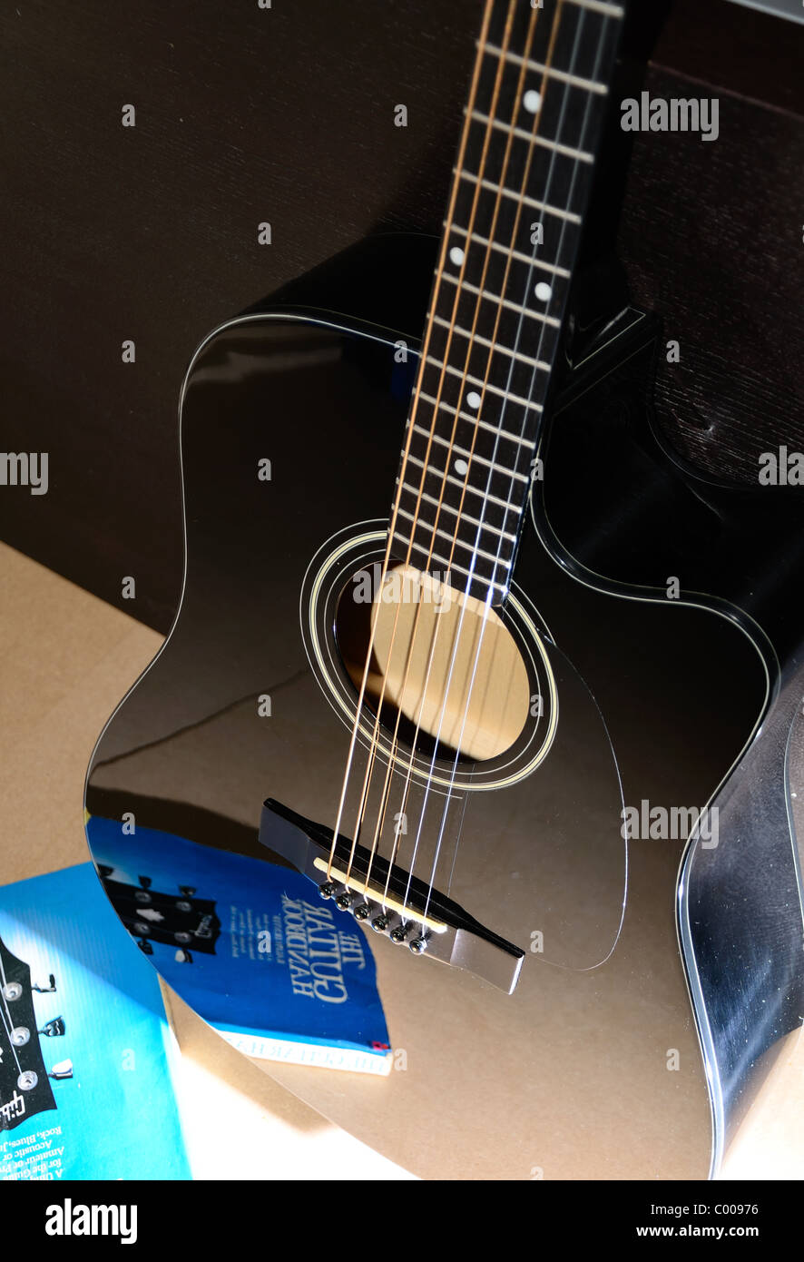 Black acoustic guitar with reflection of the guitar handbook Stock Photo