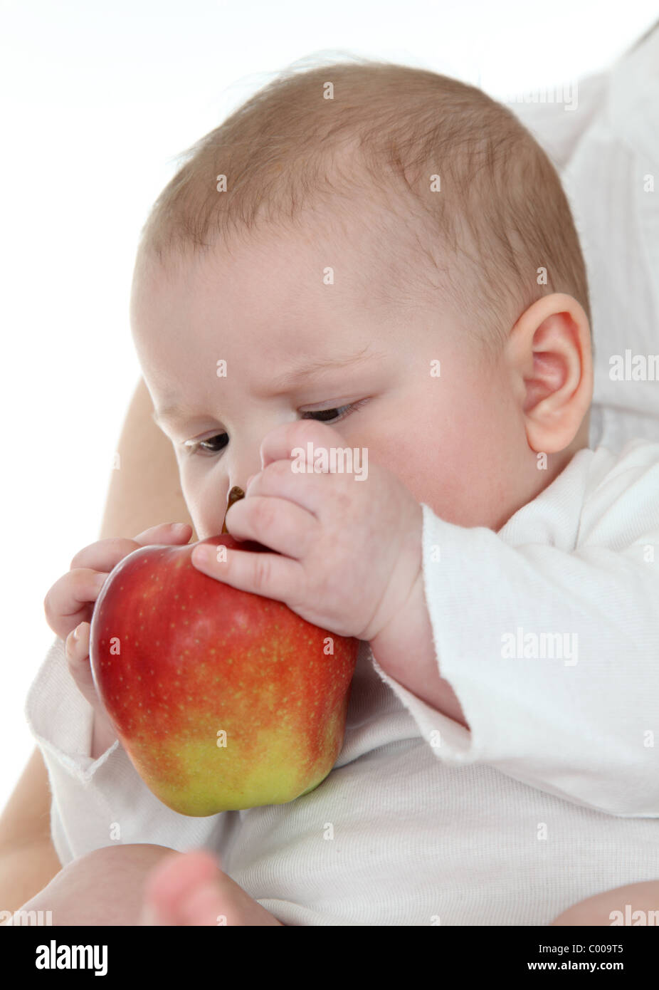 Little baby trying to eat an apple Stock Photo Alamy