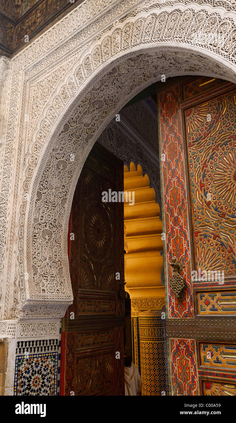 Open door of Mosque with intricate stone carving Zellige tiles and paint in Fes Medina Fez Morocco North Africa Stock Photo