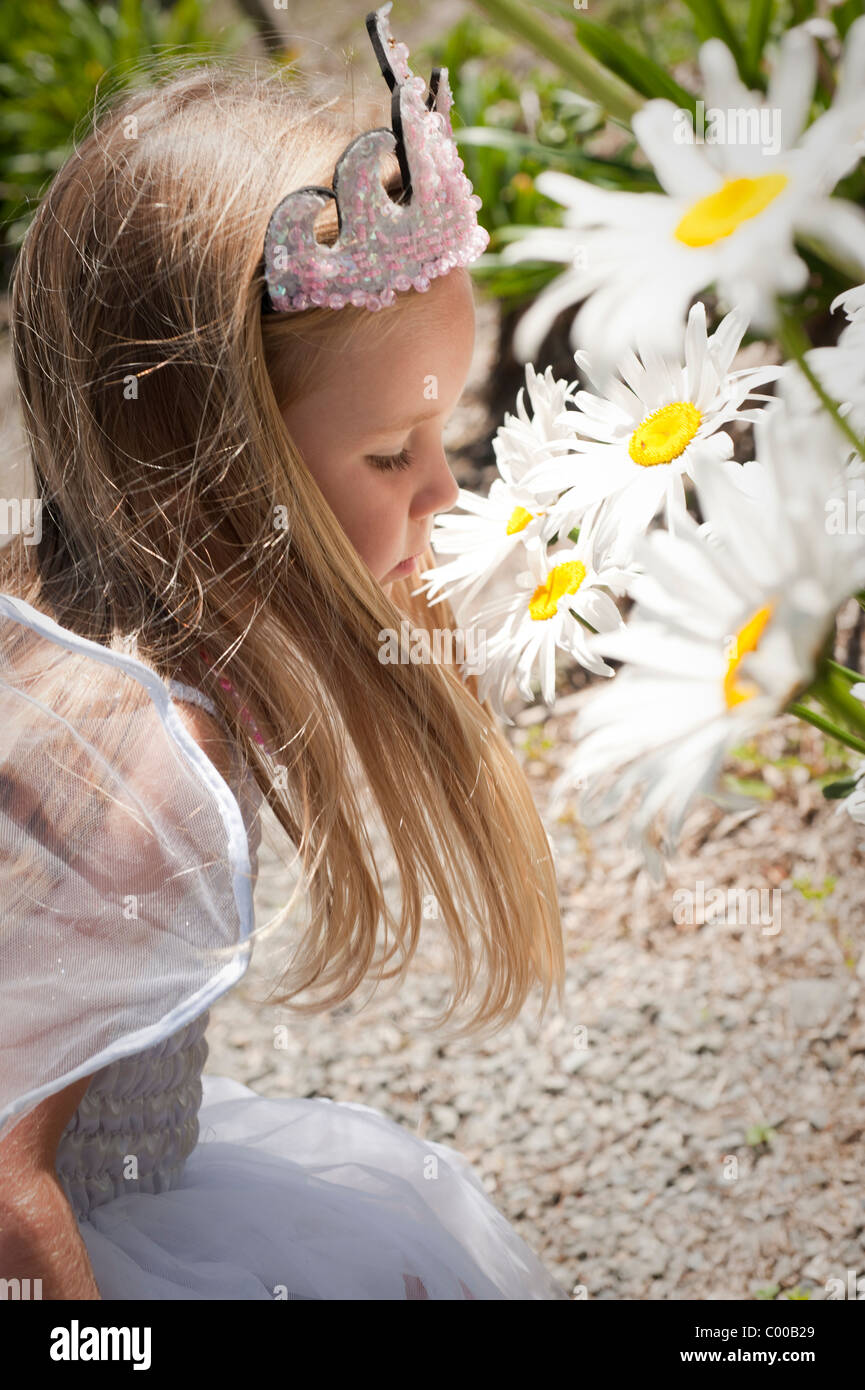 beautiful little girl enjoying smelling flowers Stock Photo - Alamy