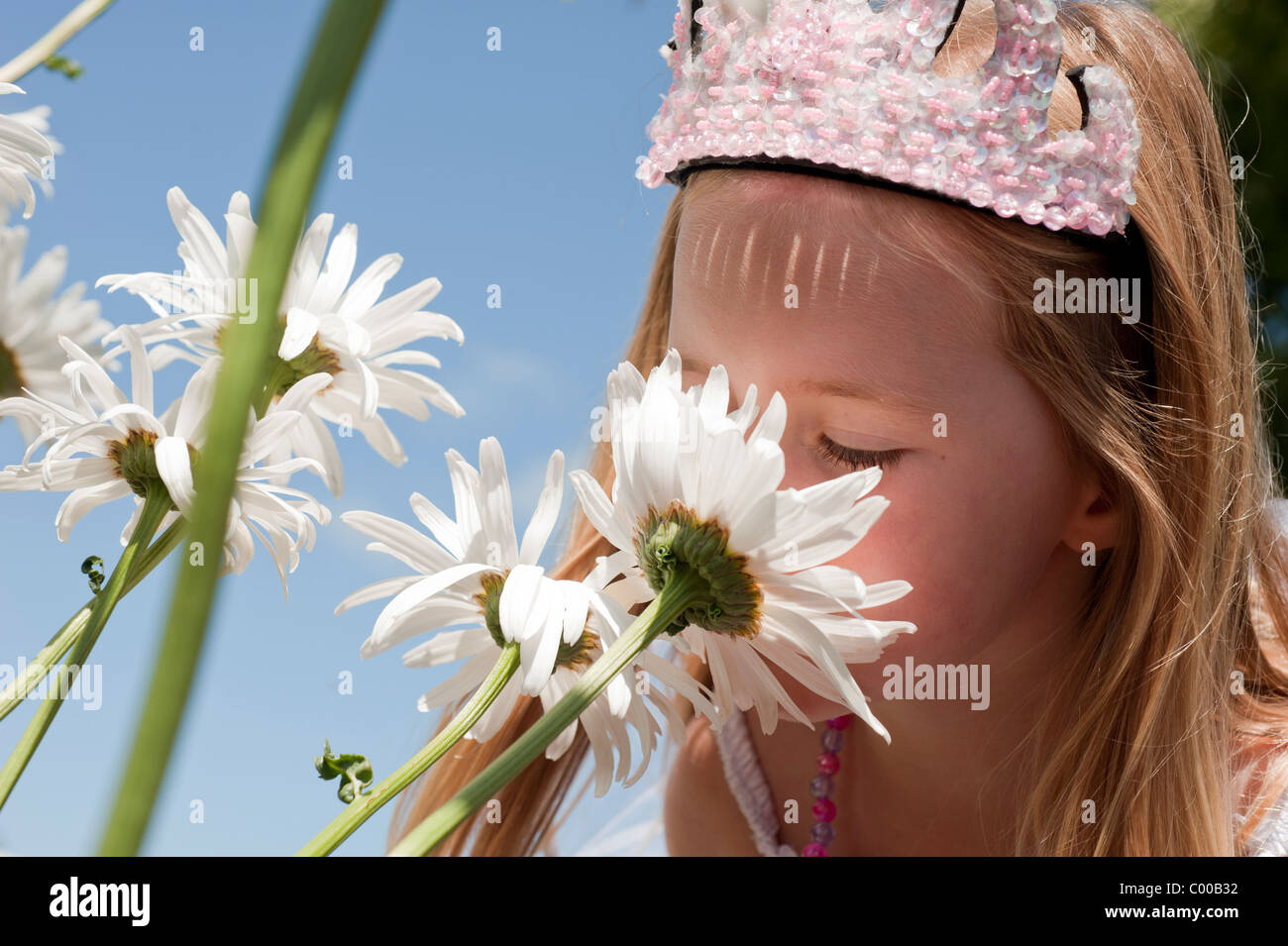 beautiful little girl enjoying smelling flowers Stock Photo - Alamy