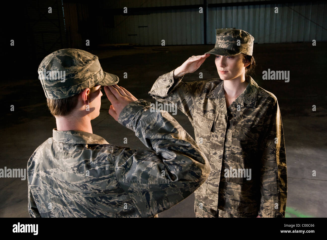 Soldiers in army combat uniform saluting Stock Photo