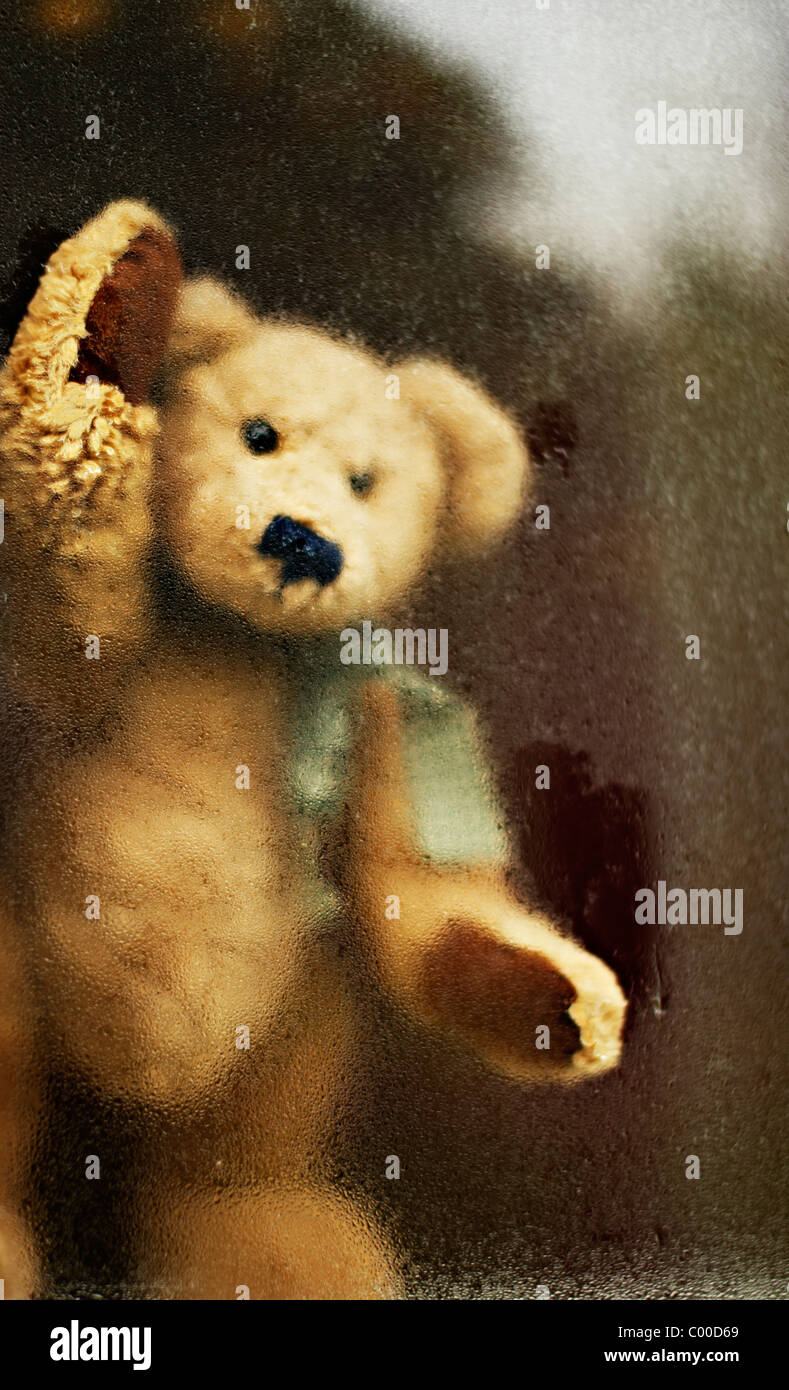 Teddy bear looks out of window Stock Photo