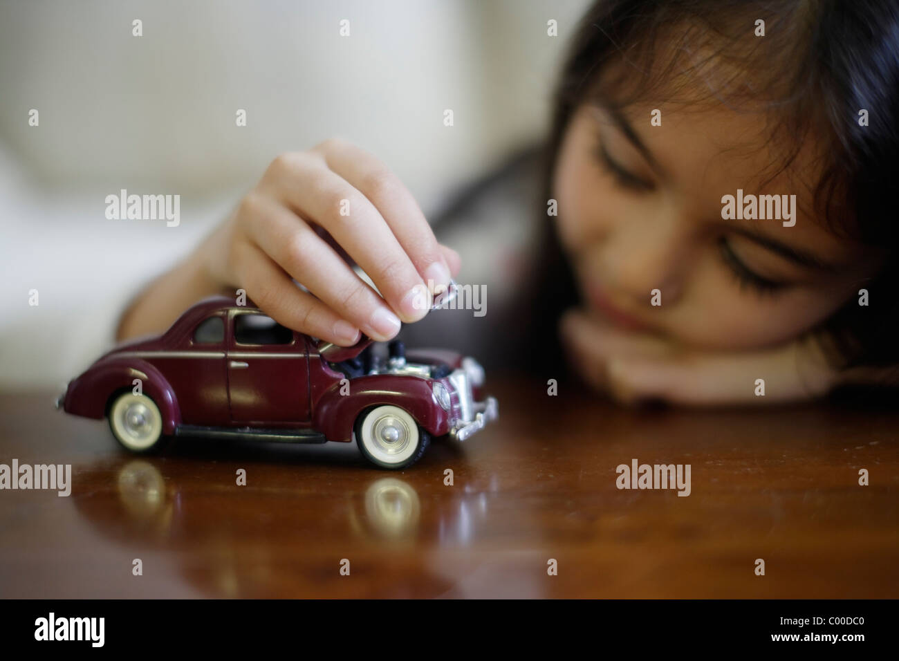 Girl plays with toy cars Stock Photo