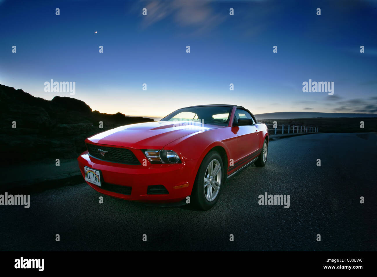 A red Ford Mustang rental car at night in Hawaii Stock Photo