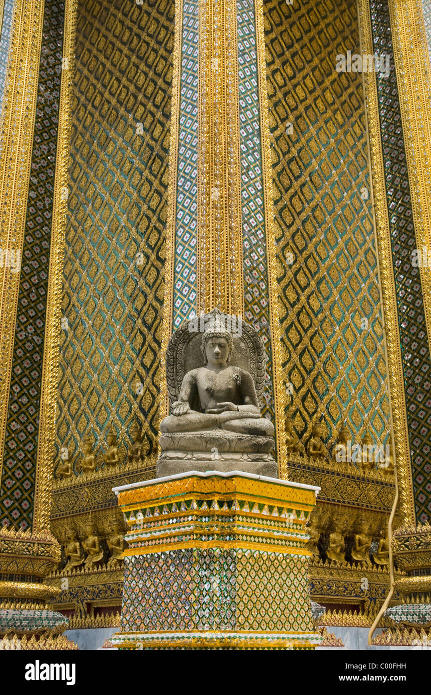 Small stone buddha statue beside columns of Wat Phra Kaew temple Stock