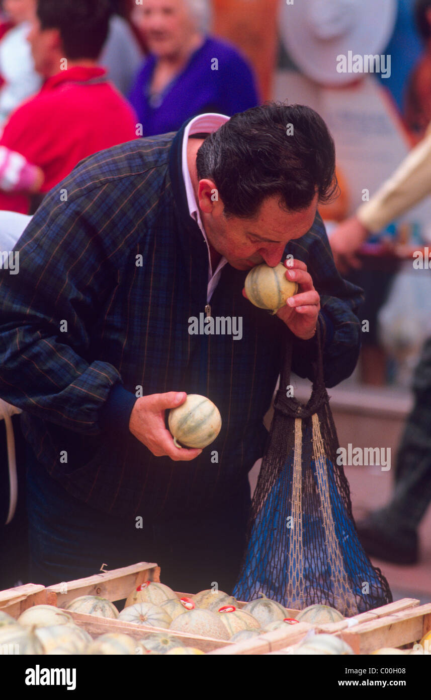 A man smelling a melon to find out if it is ripe Stock Photo Alamy