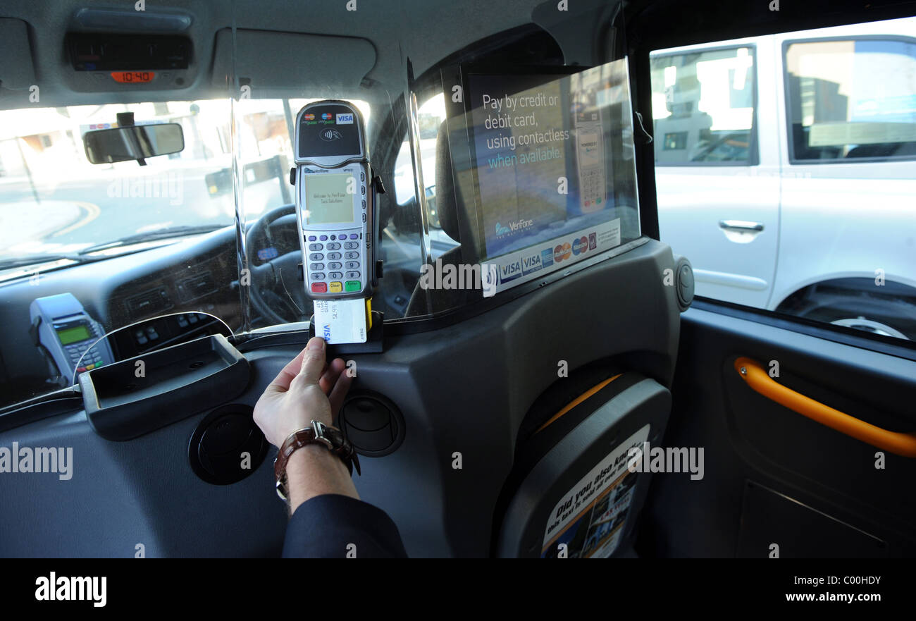 A man pay for a Taxi using a newly installed Verifone machine which takes payments from debit or