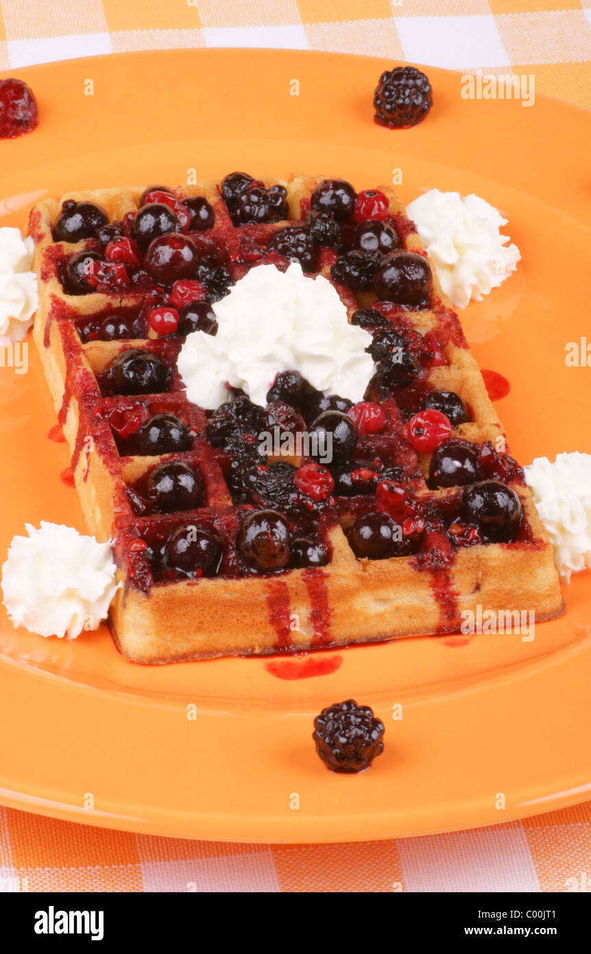 Waffle with soft fruits and whipped cream on an orange plate Stock ...