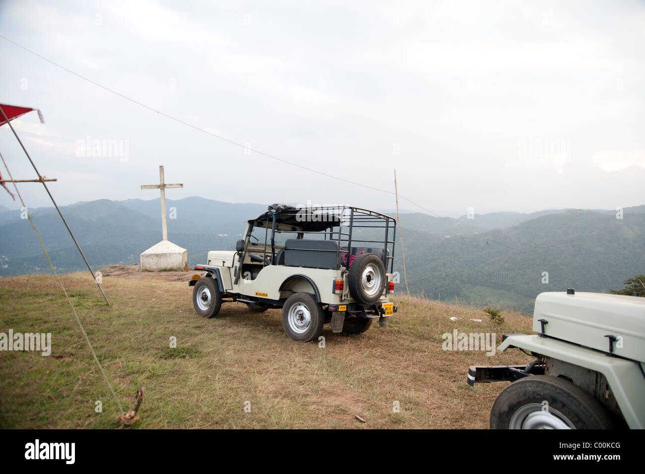 Cross and vehicles on top of a hill near Thekkady in the state of Kerala in India. A number of people visit this location. Stock Photo