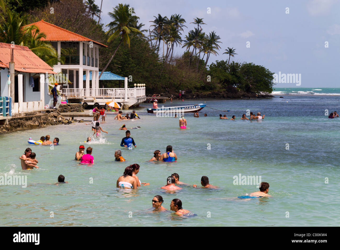 Tourists enjoying time at the beach under the eye of a Civil Protection life saver. Isla Grande, Colon, Republic of Panama Stock Photo