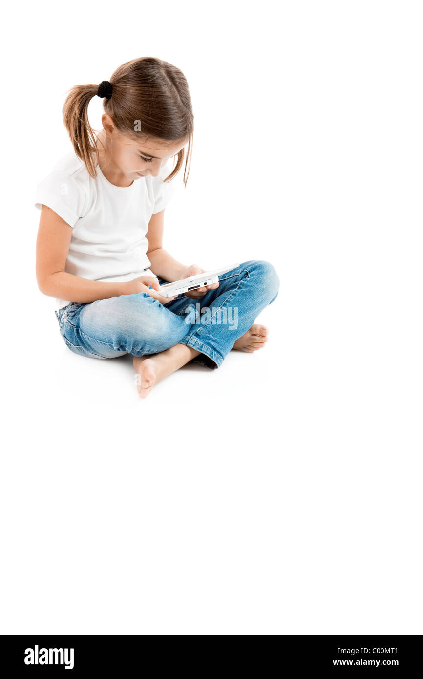 Little girl sitting on floor playing a video-game Stock Photo