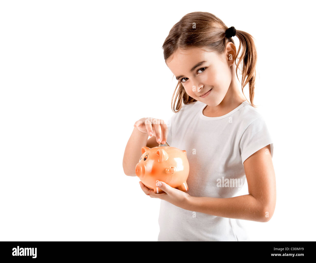 Little girl holding a piggy-bank and inserting a one euro coin Stock ...