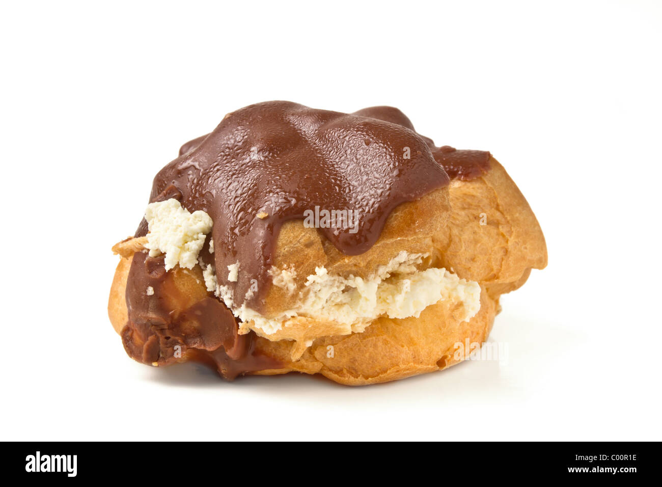 Chocolate covered choux bun cream cake from low perspective isolated on white. Stock Photo
