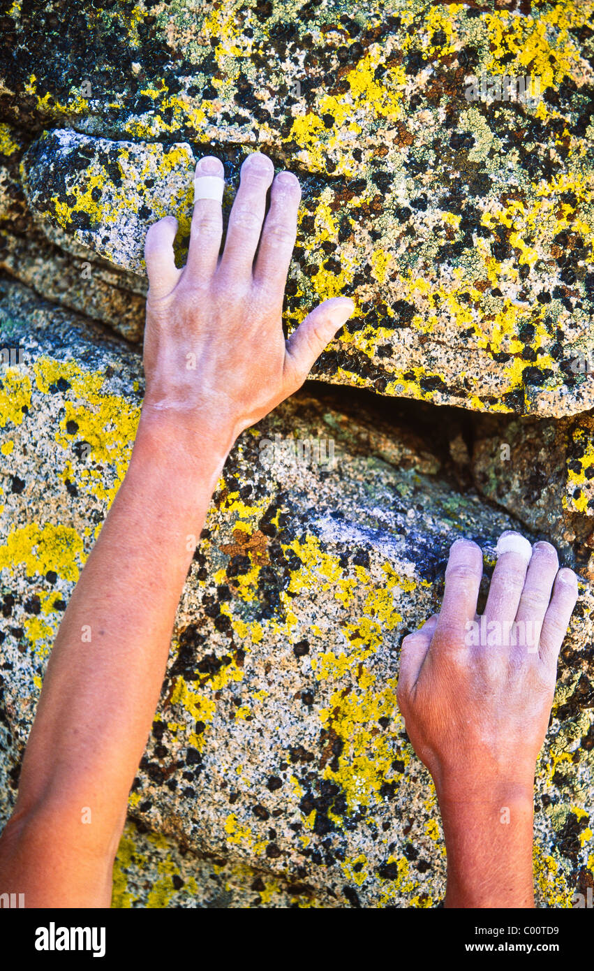 Rock climber reaching for the next hand hold on a steep wall. Stock Photo