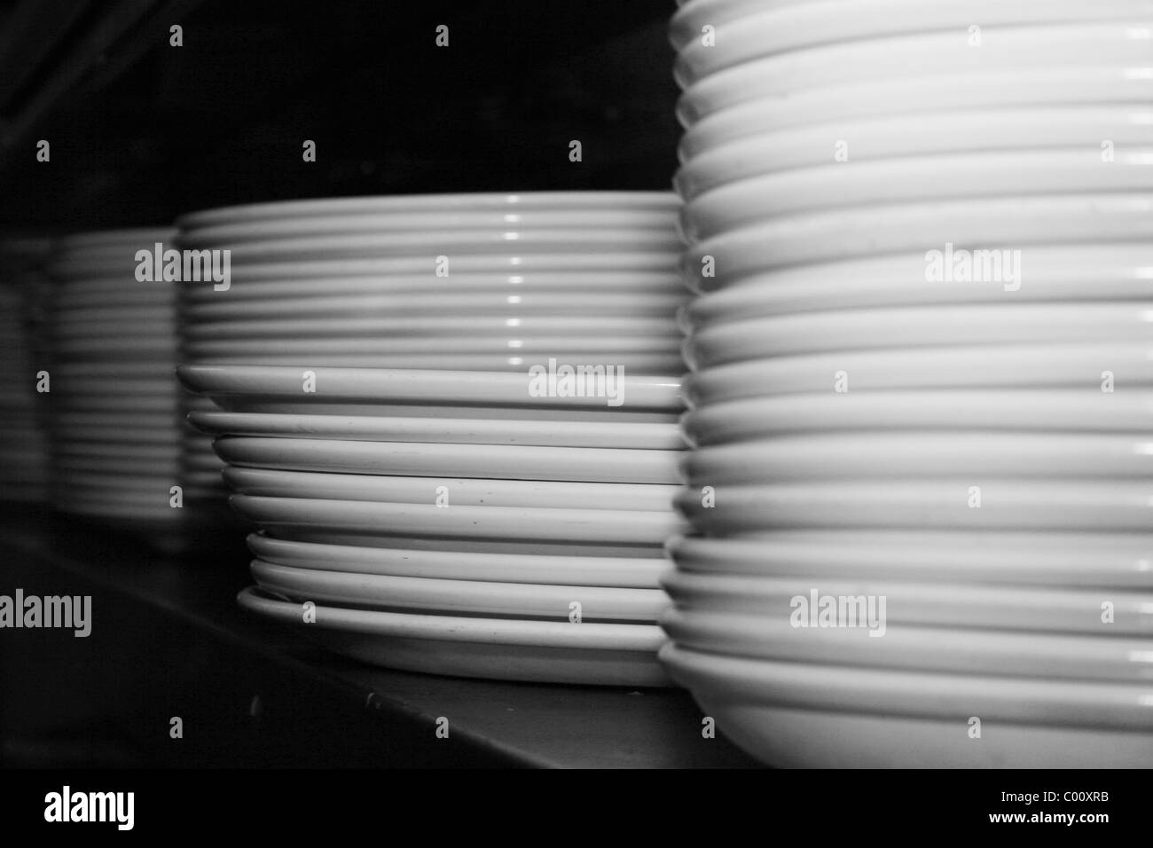 stacked plates on shelf in kitchen Stock Photo