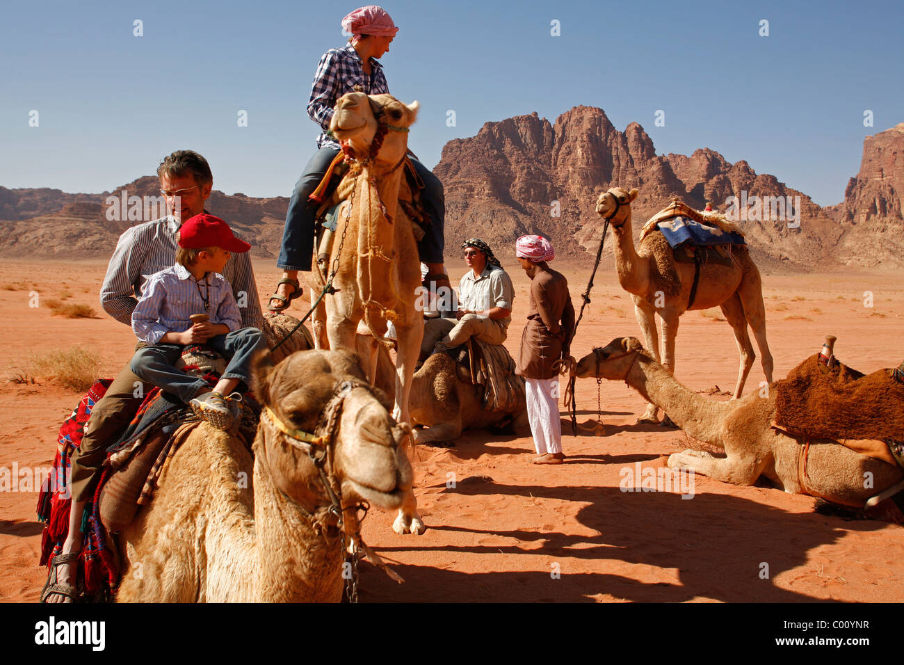 Tourists riding camels in the desert, Wadi Rum, Jordan. Stock Photo