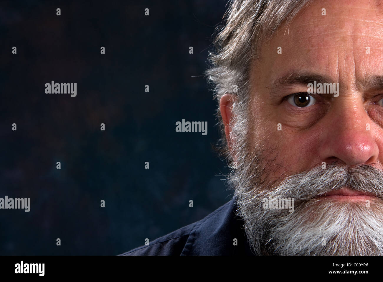 Serious look on a mature man's half face. Room for copy on left. Stock Photo