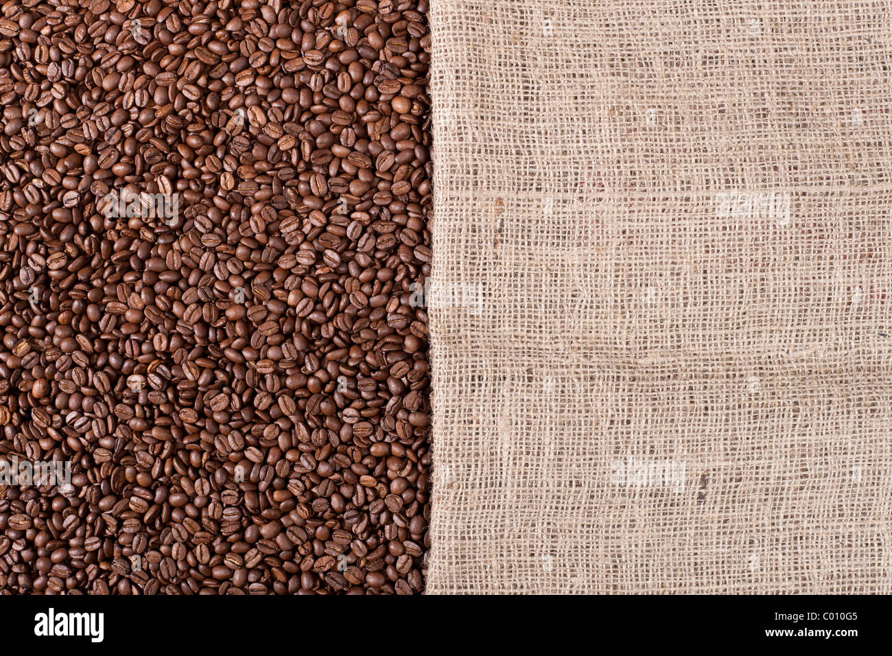 Background image of many coffee beans and a canvas sack filling the picture Stock Photo