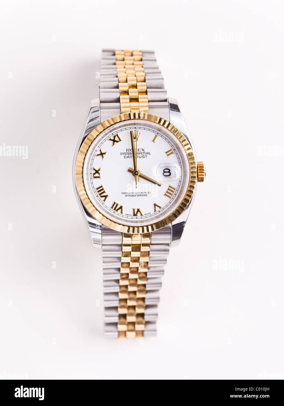 Expensive gold beveled Rolex watch with white face and gold hands and numerals against white background Stock Photo
