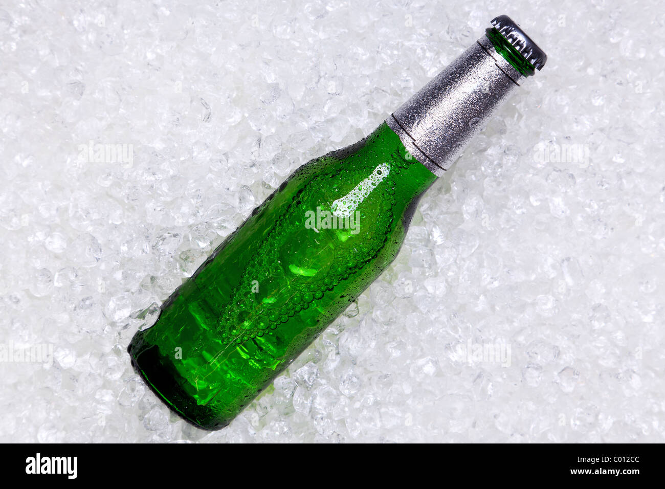 Photo of a green glass bottle of beer on crushed ice. Stock Photo