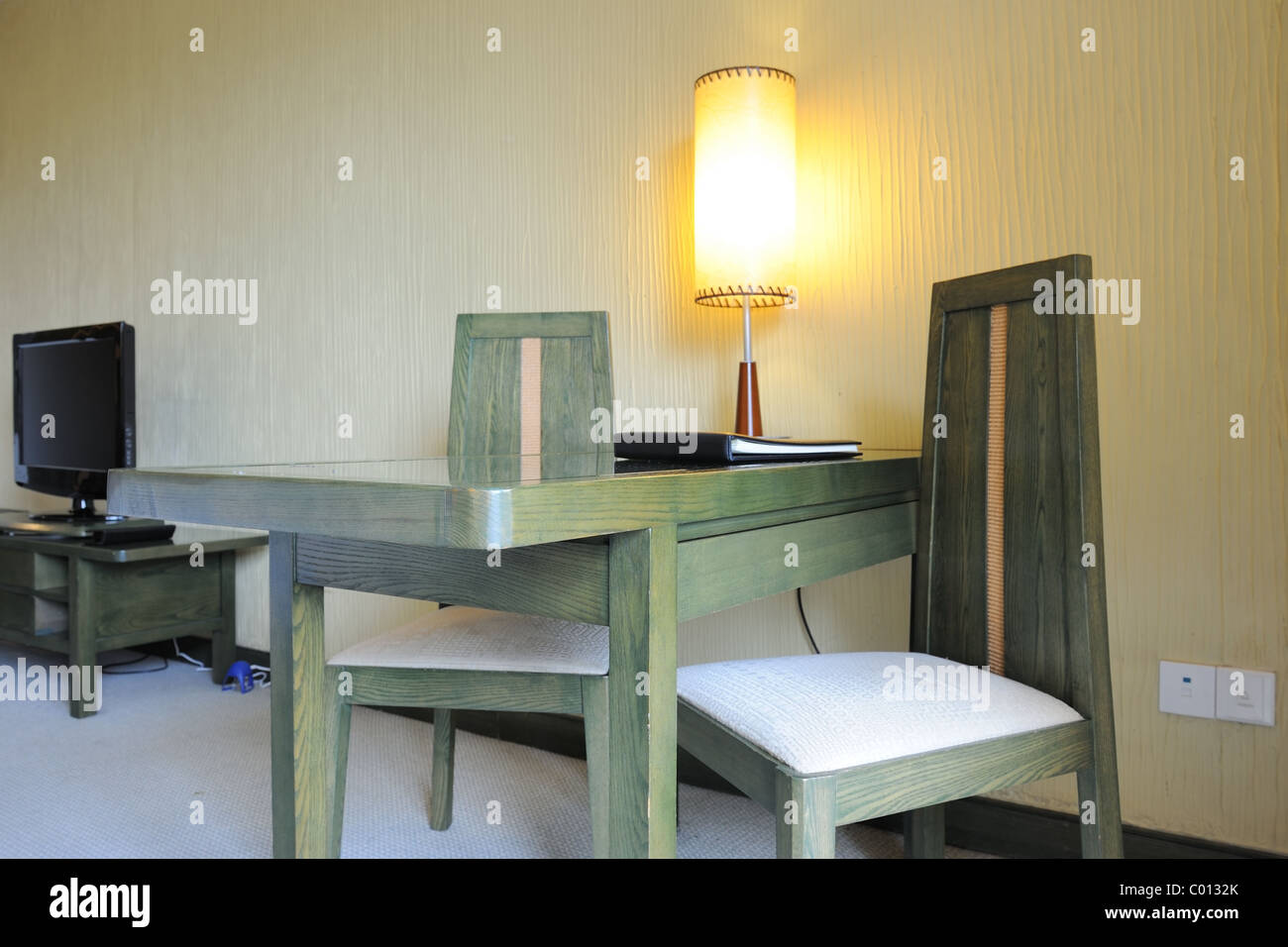 Desk with lamp on it and chairs in the room Stock Photo