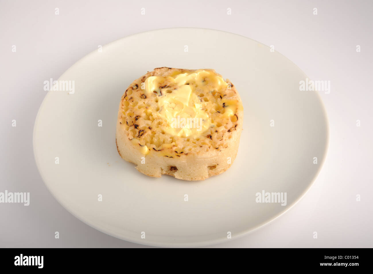 Hot Crumpet with butter on a plate Stock Photo