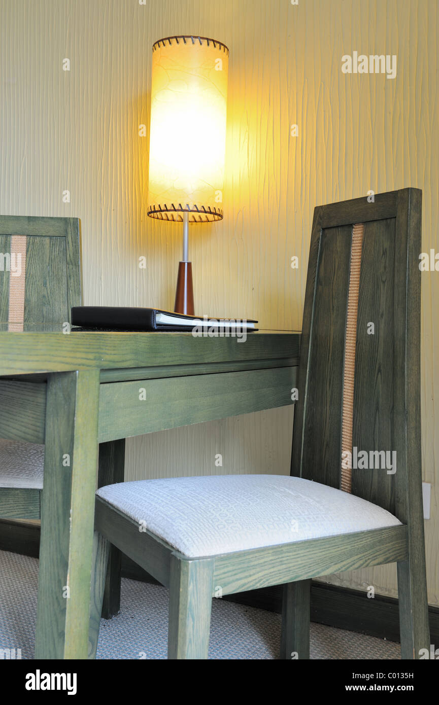 Desk with lamp on it and chairs in the room Stock Photo