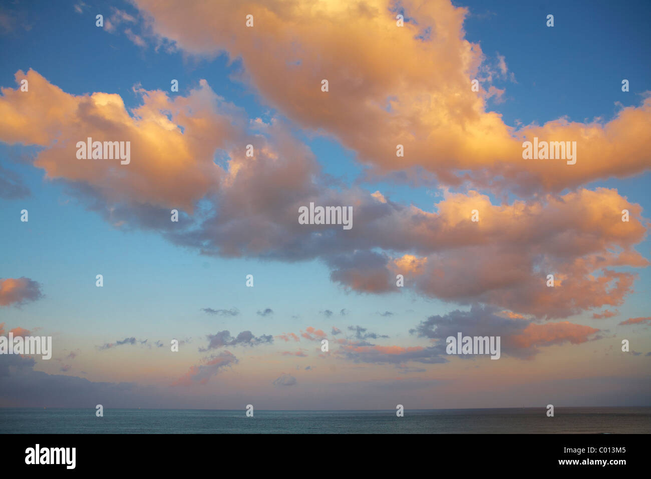 Blue sky with clouds in the evening light Stock Photo - Alamy
